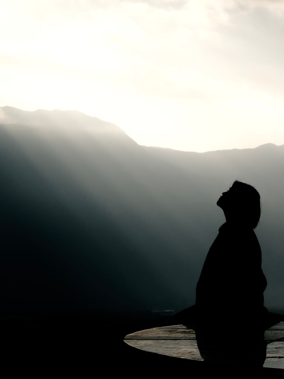 Pessoa meditando ao entardecer no topo da montanha